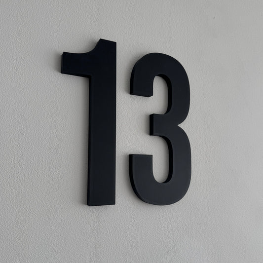 Zwart 3D huisnummer 13 op witte wand - Dunesign